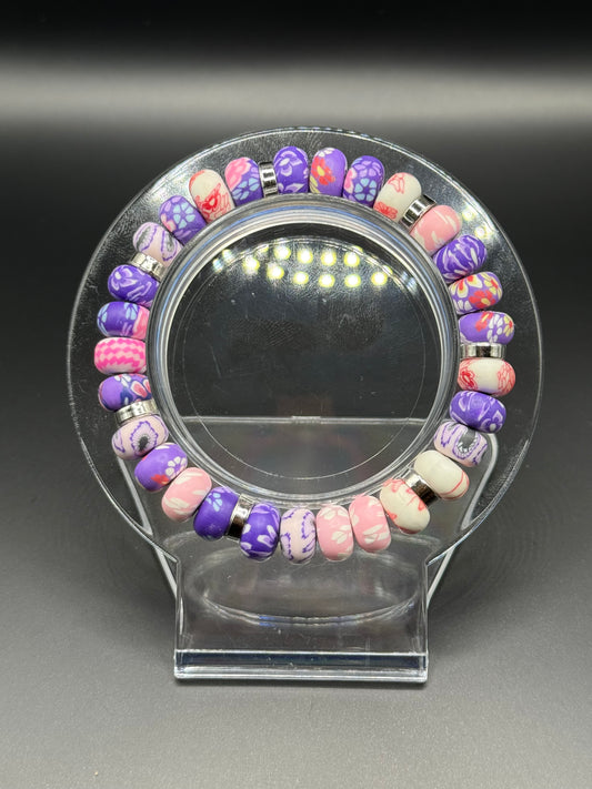 Colorful beaded bracelet on a clear stand with a dark background